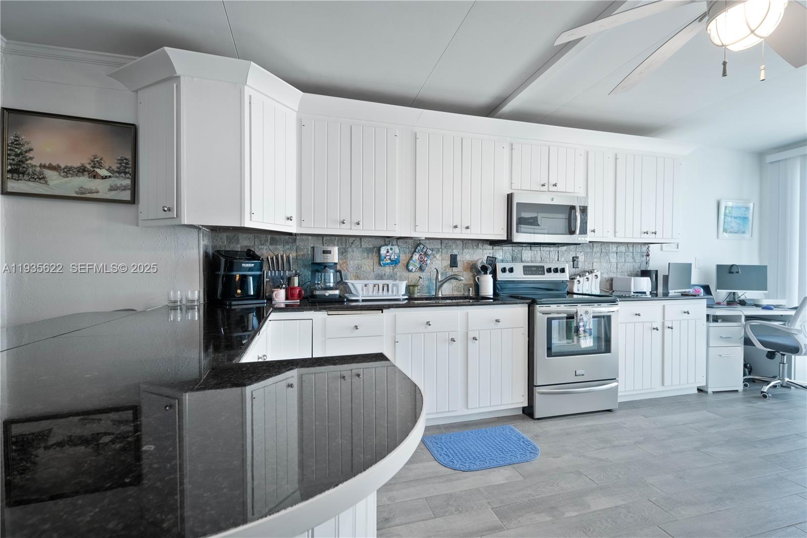 1361 Overseas Highway, Unit E11 Marathon, FL 33050 - Photo 14 of 29 a kitchen with granite countertop white cabinets sink and stainless steel appliances