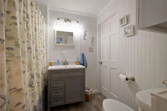 a bathroom with a granite countertop sink toilet a mirror and shower