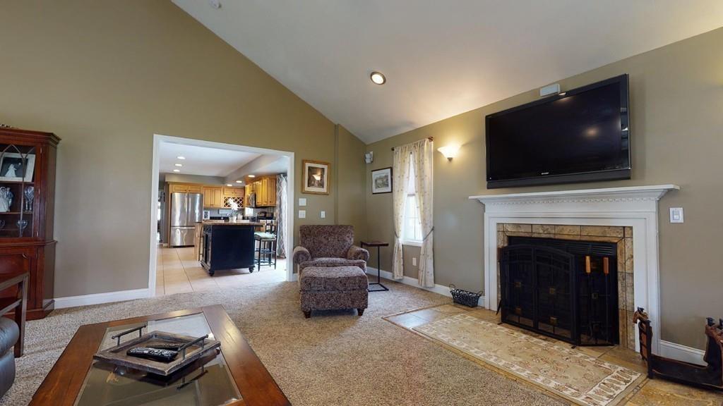 98 Haggerty Road Charlton, MA 01507 - Photo 11 of 42 a living room with furniture a flat screen tv and a fireplace