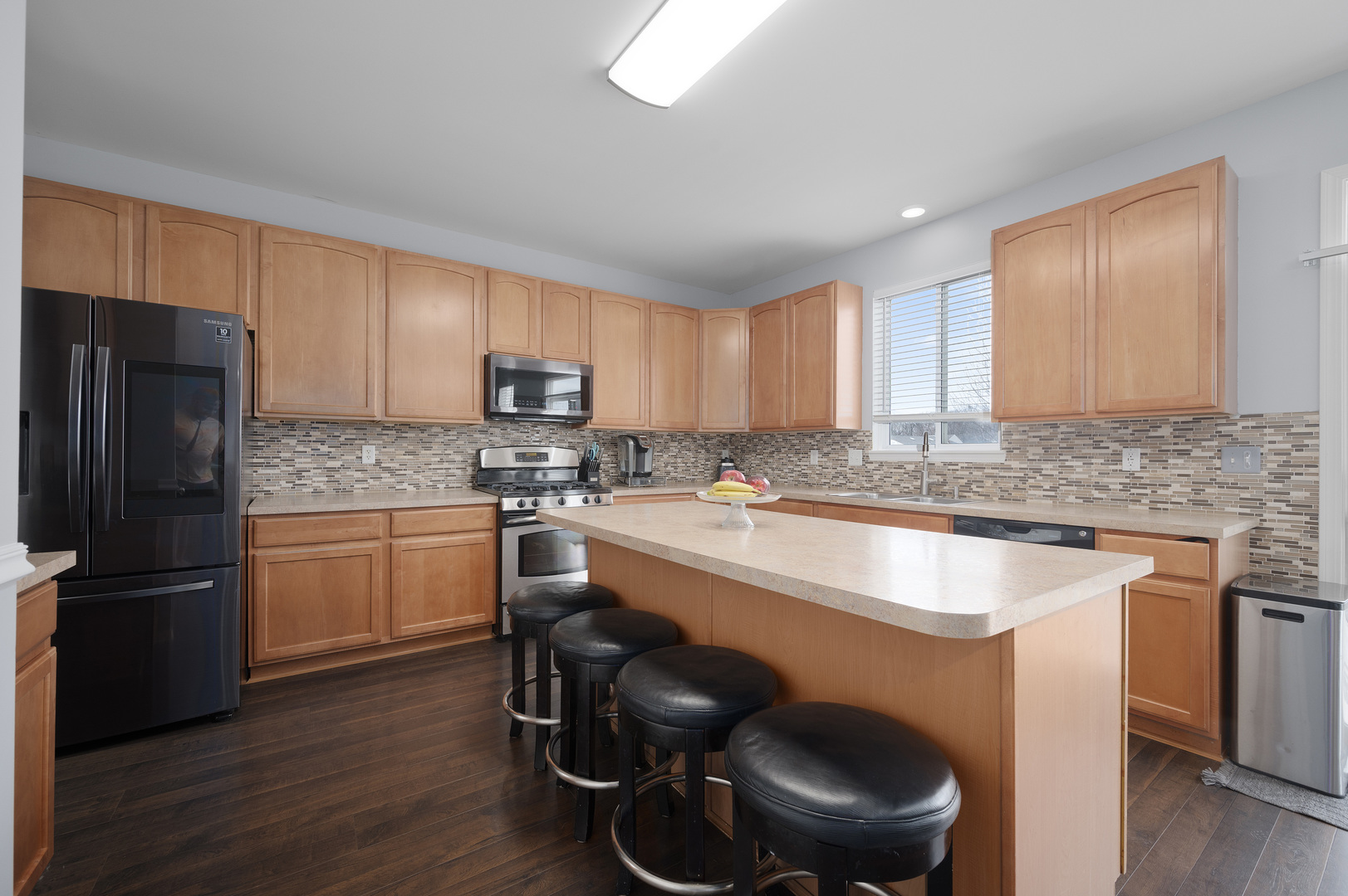 419 Riverbend Drive Genoa, IL 60135 - Photo 7 of 42 a kitchen with a sink a refrigerator a stove a microwave and cabinets