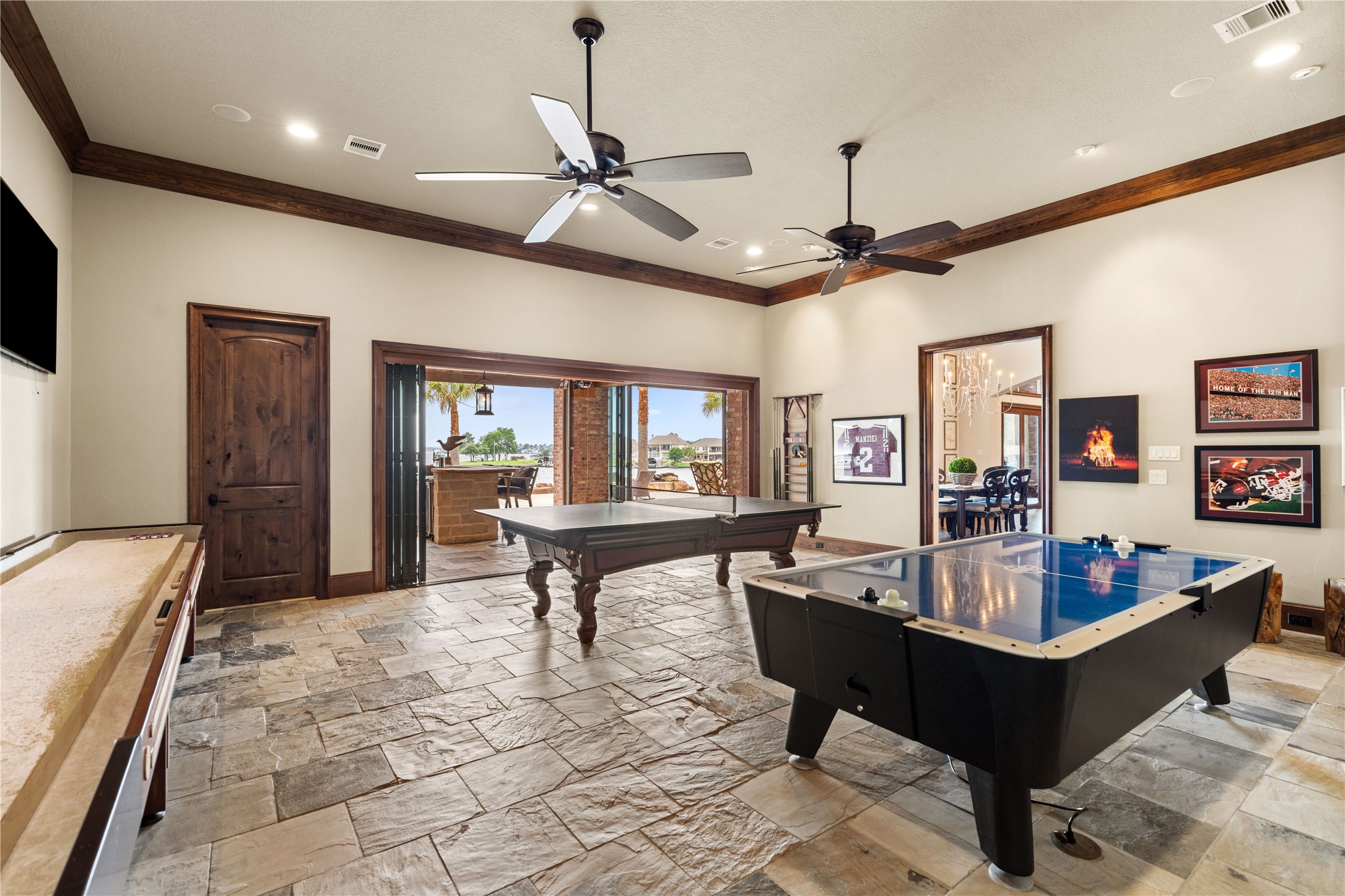 12349 Longmire Trace Conroe, TX 77304 - Photo 16 of 48 Expansive game room with stone flooring, wood-trim ceilings, and wide sliders opening to the covered patio.