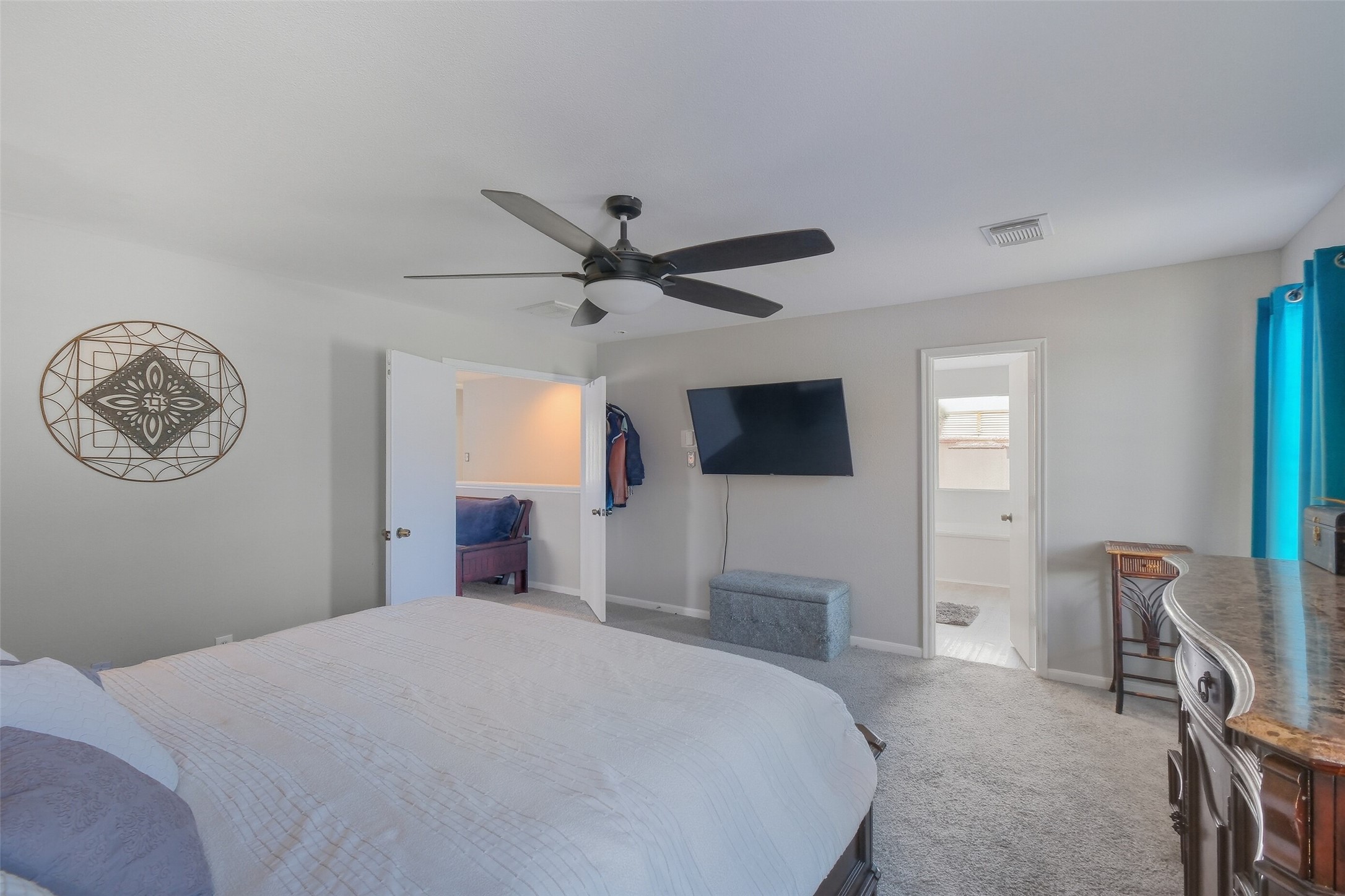 2934 Valiant Scene Court Houston, TX 77038 - Photo 13 of 28 a bedroom with a large bed a flat tv screen and a chandelier