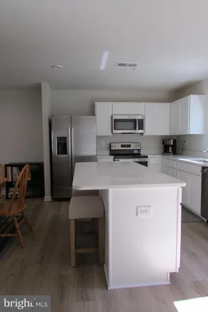 a kitchen with kitchen island a stove cabinets and sink