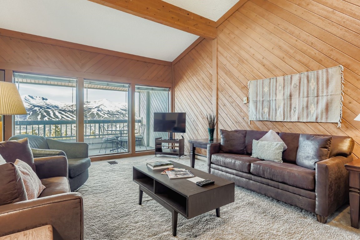 a living room with furniture a large window and a table