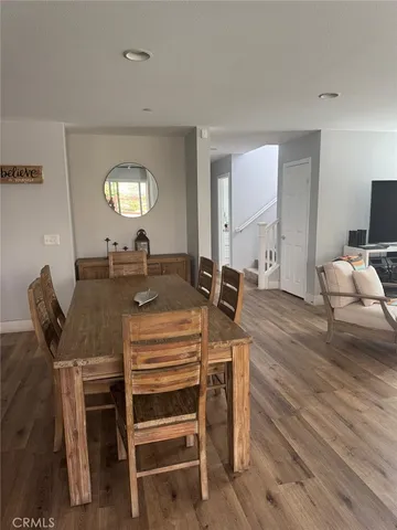 a view of a a dining room with furniture window and wooden floor