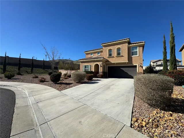 a front view of a house with cars parked