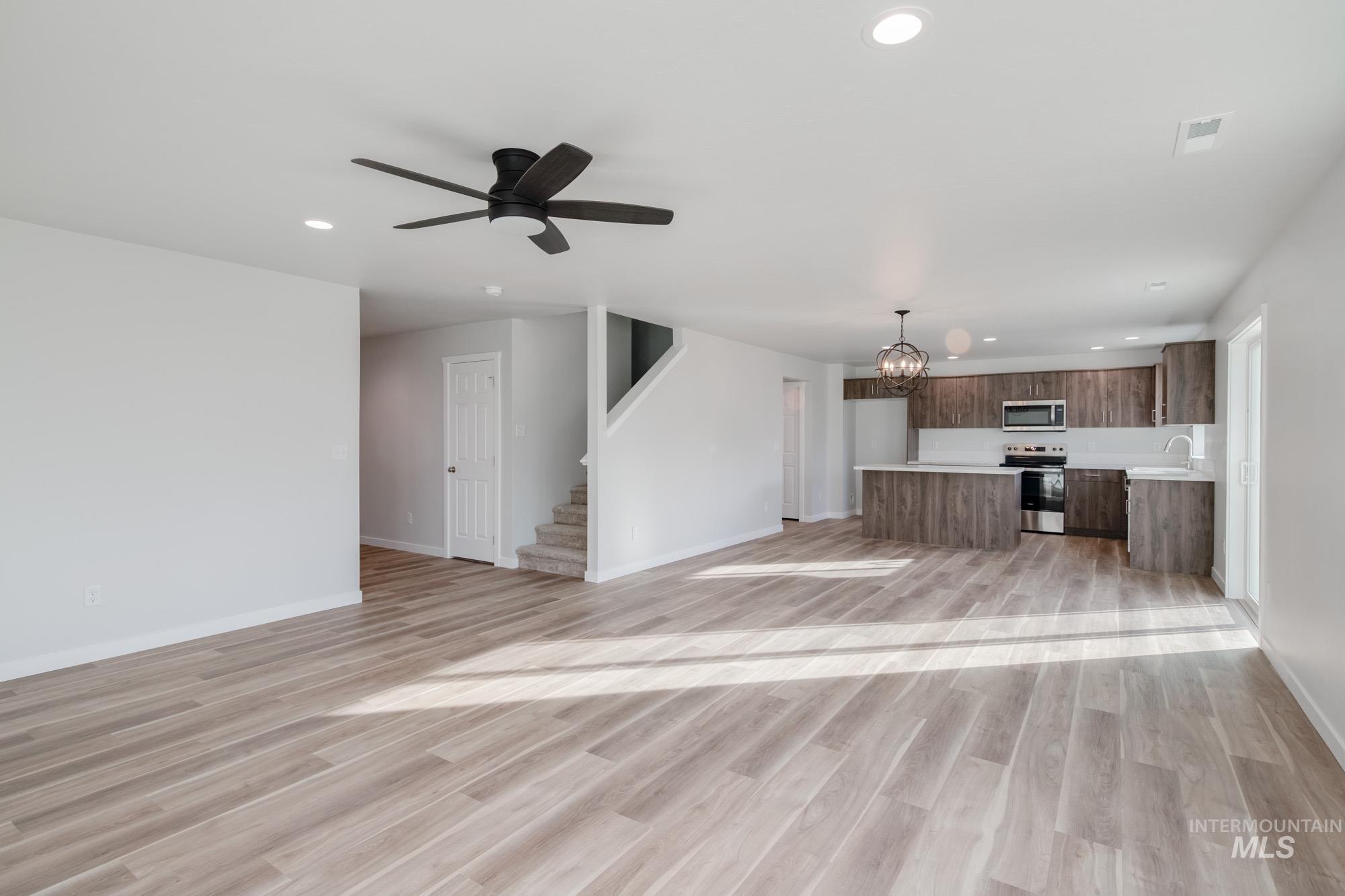 1613 Covington Street Middleton, ID 83644 - Photo 14 of 25 Unfurnished living room with suspended lighting, a ceiling fan, and light wood-style flooring