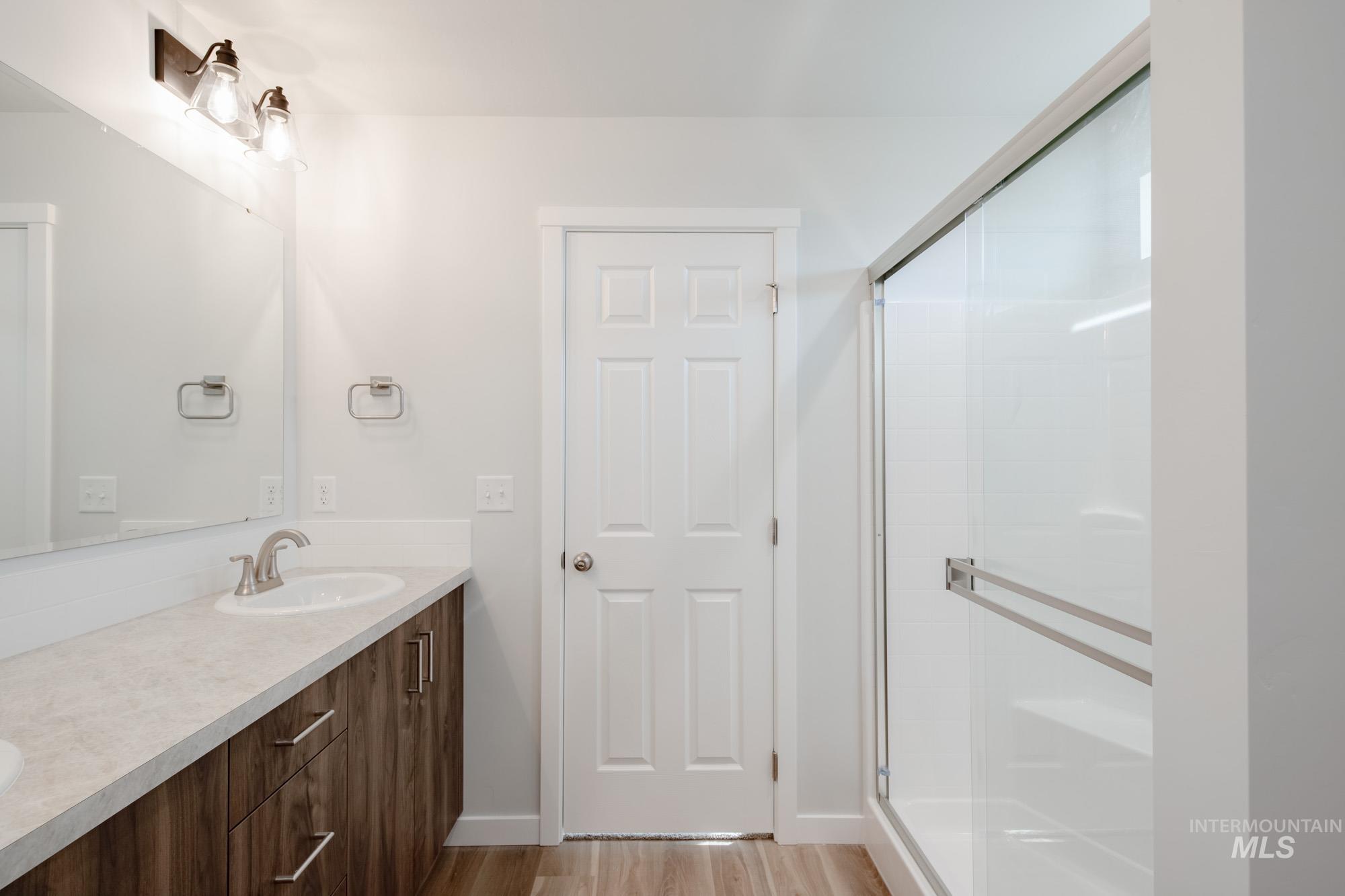 1613 Covington Street Middleton, ID 83644 - Photo 25 of 25 Bathroom with a stall shower, double vanity, and light wood-style floors