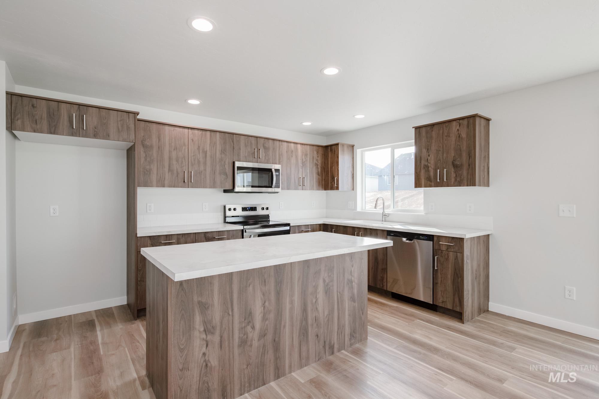 1613 Covington Street Middleton, ID 83644 - Photo 3 of 25 Kitchen with a kitchen island, stainless steel appliances, light wood-type flooring, modern cabinets, and recessed lighting