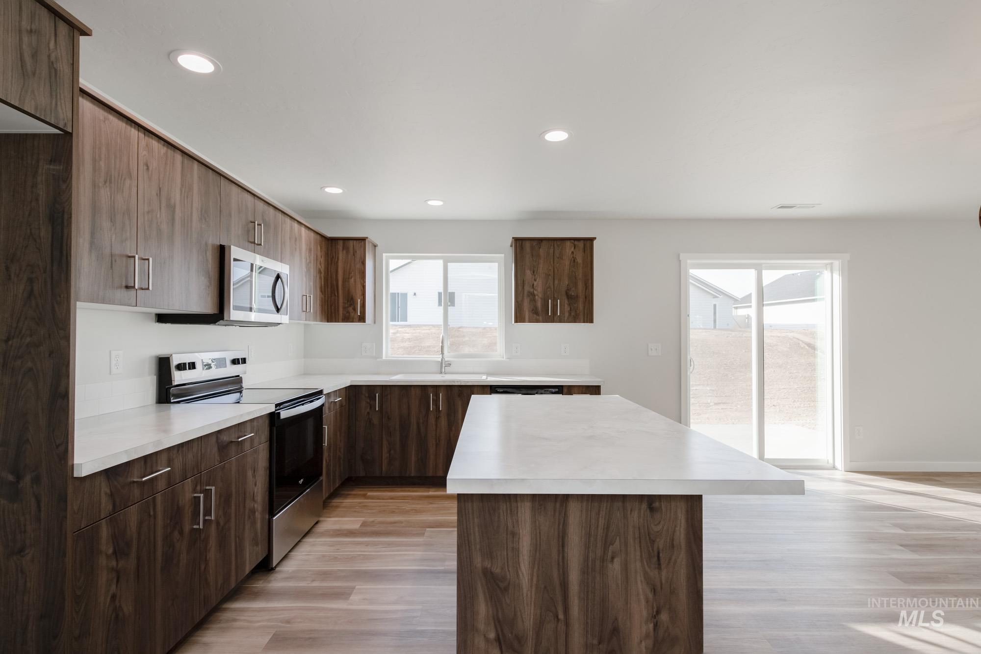 1613 Covington Street Middleton, ID 83644 - Photo 6 of 25 Kitchen with stainless steel appliances, a center island, light countertops, recessed lighting, and light wood finished floors