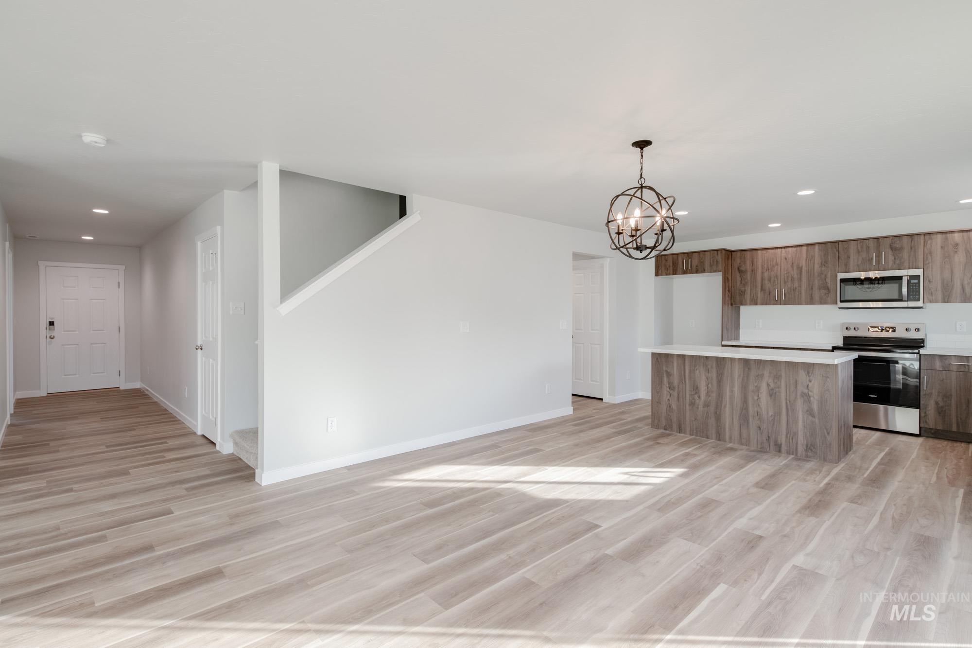 1613 Covington Street Middleton, ID 83644 - Photo 10 of 25 Kitchen featuring a center island, light countertops, stainless steel appliances, a chandelier, and light wood-style floors