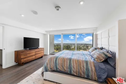 a bedroom with a bed and large window