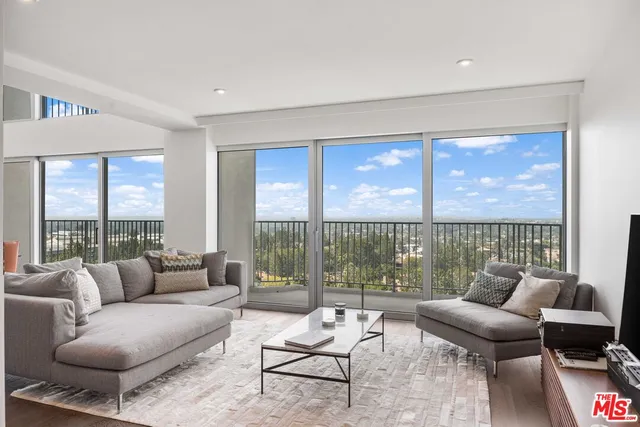 a living room with furniture and a floor to ceiling window