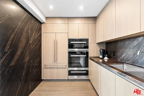 a kitchen with granite countertop a refrigerator and a sink