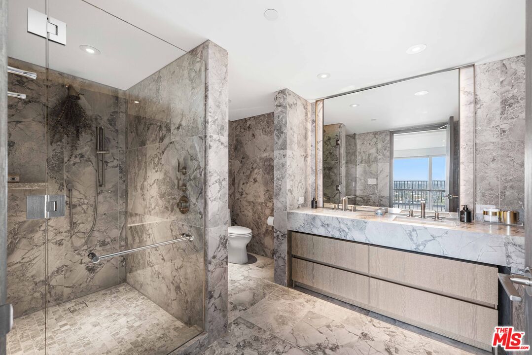 2025 Avenue Of The Stars, Unit 1202 Los Angeles, CA 90067 - Photo 9 of 20 a bathroom with a double vanity sink toilet mirror and shower