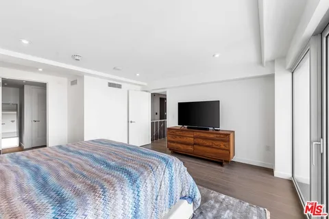 a bedroom with a bed and a flat screen tv