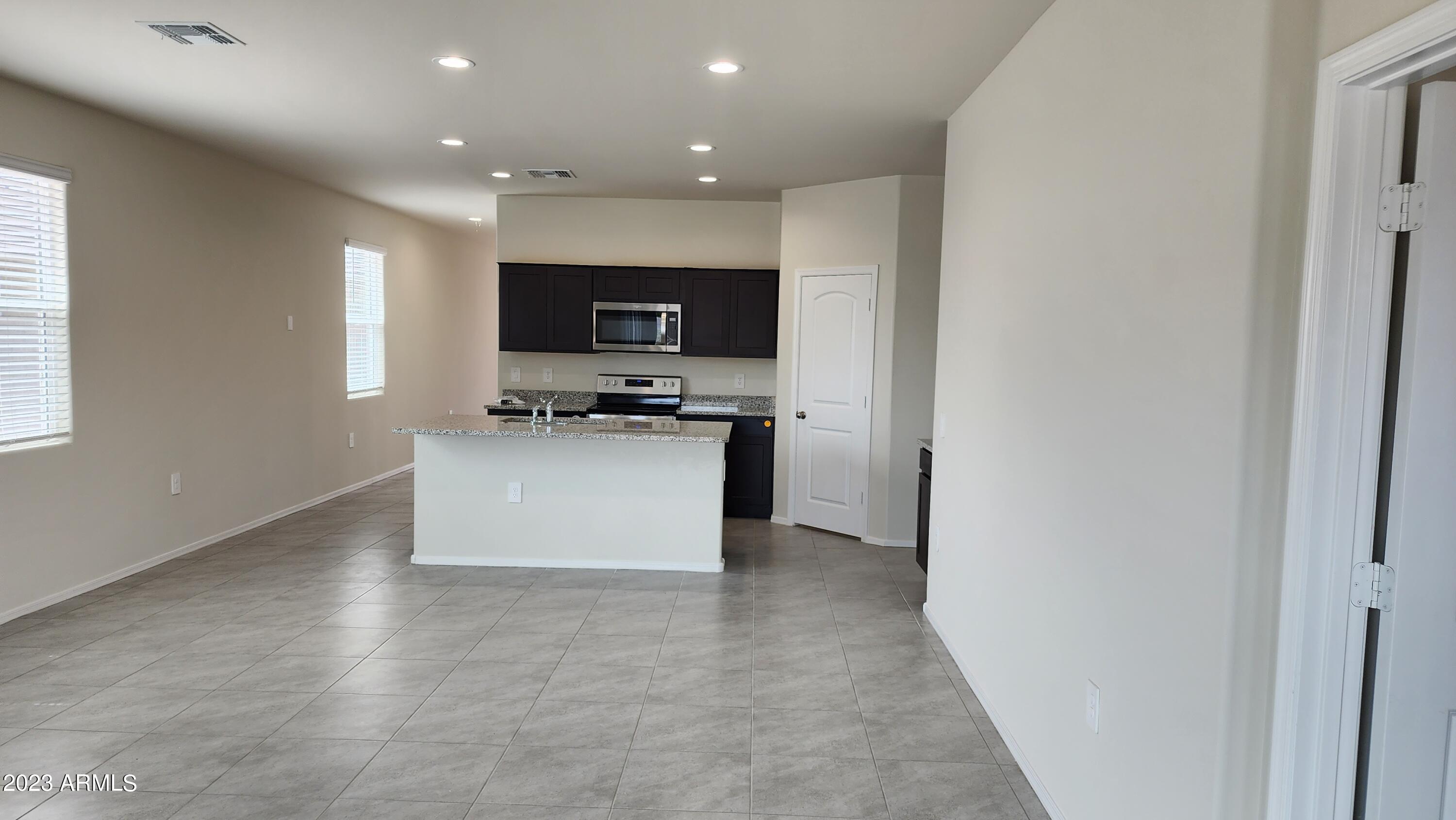 18045 North Conquistador Drive Maricopa, AZ 85138 - Photo 3 of 12 a view of kitchen with kitchen island stainless steel appliances a sink and a stove top oven with wooden floor