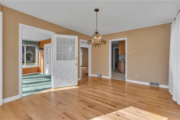 a view of a livingroom with wooden floor staircase and a kitchen space