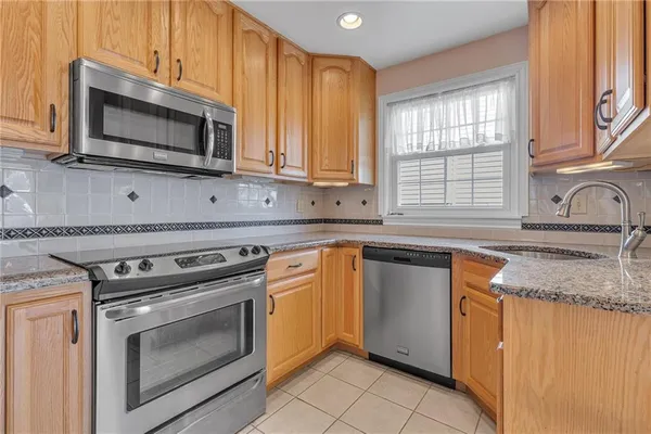 a kitchen with granite countertop a sink stove and microwave