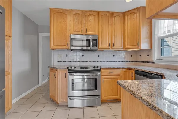a kitchen with stainless steel appliances granite countertop a stove a sink and a microwave