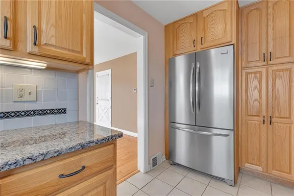 a view of a kitchen with granite countertop cabinets and refrigerator