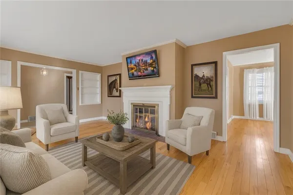 a living room with furniture a fireplace and a wooden floor