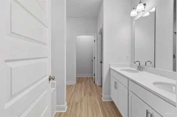 a bathroom with a sink a toilet a mirror and shower