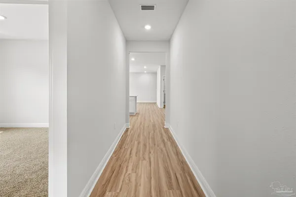 a view of a hallway with wooden floor and staircase