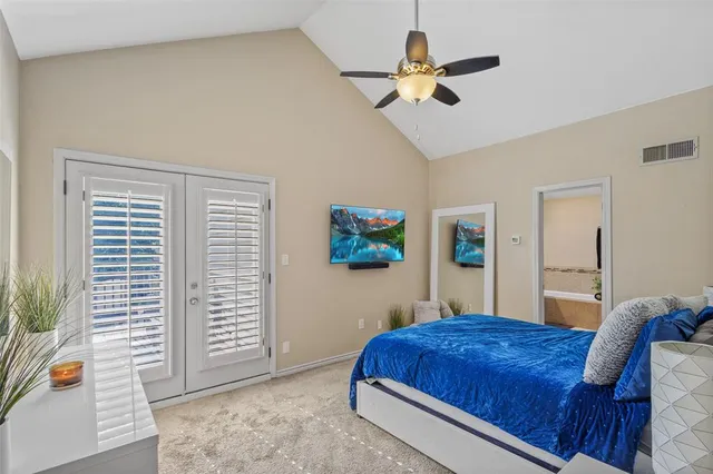 a bedroom with a large bed a chandelier and a window