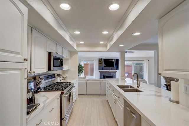 a large kitchen with stainless steel appliances granite countertop a sink stove and refrigerator