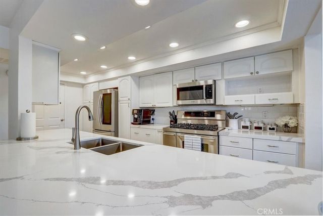 a kitchen with granite countertop a stove and a sink