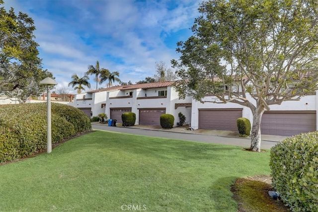 a front view of a house with a garden and trees