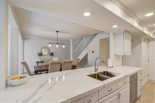 a kitchen with sink refrigerator and cabinets