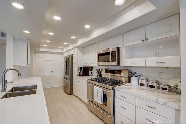a kitchen with stainless steel appliances kitchen island granite countertop a sink and cabinets