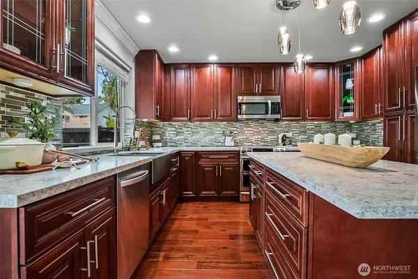 a kitchen with stainless steel appliances a sink stove and cabinets