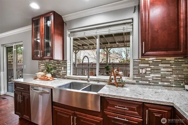 a kitchen with stainless steel appliances granite countertop a kitchen island hardwood floor a dining table and chairs