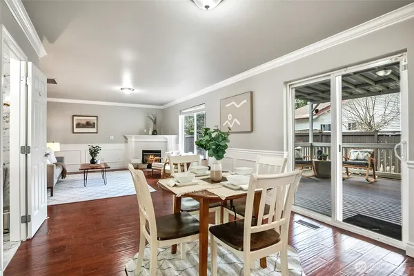 a dining room with furniture a floor to ceiling window and wooden floor