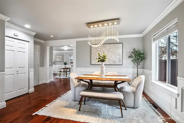 a dining room with wooden floor a chandelier a glass table and chairs