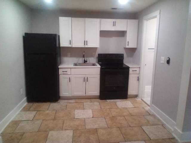 2113 River Road, Unit C San Marcos, TX 78666 - Photo 4 of 9 Kitchen featuring white cabinets, black appliances, and light countertops
