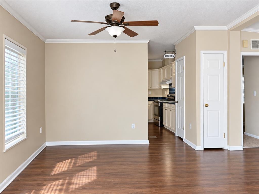 301 South Coppell Road, Unit 51 Coppell, TX 75019 - Photo 9 of 20 Wood-finish flooring, ceiling fan, window with blinds, crown molding, and a built-in kitchen
