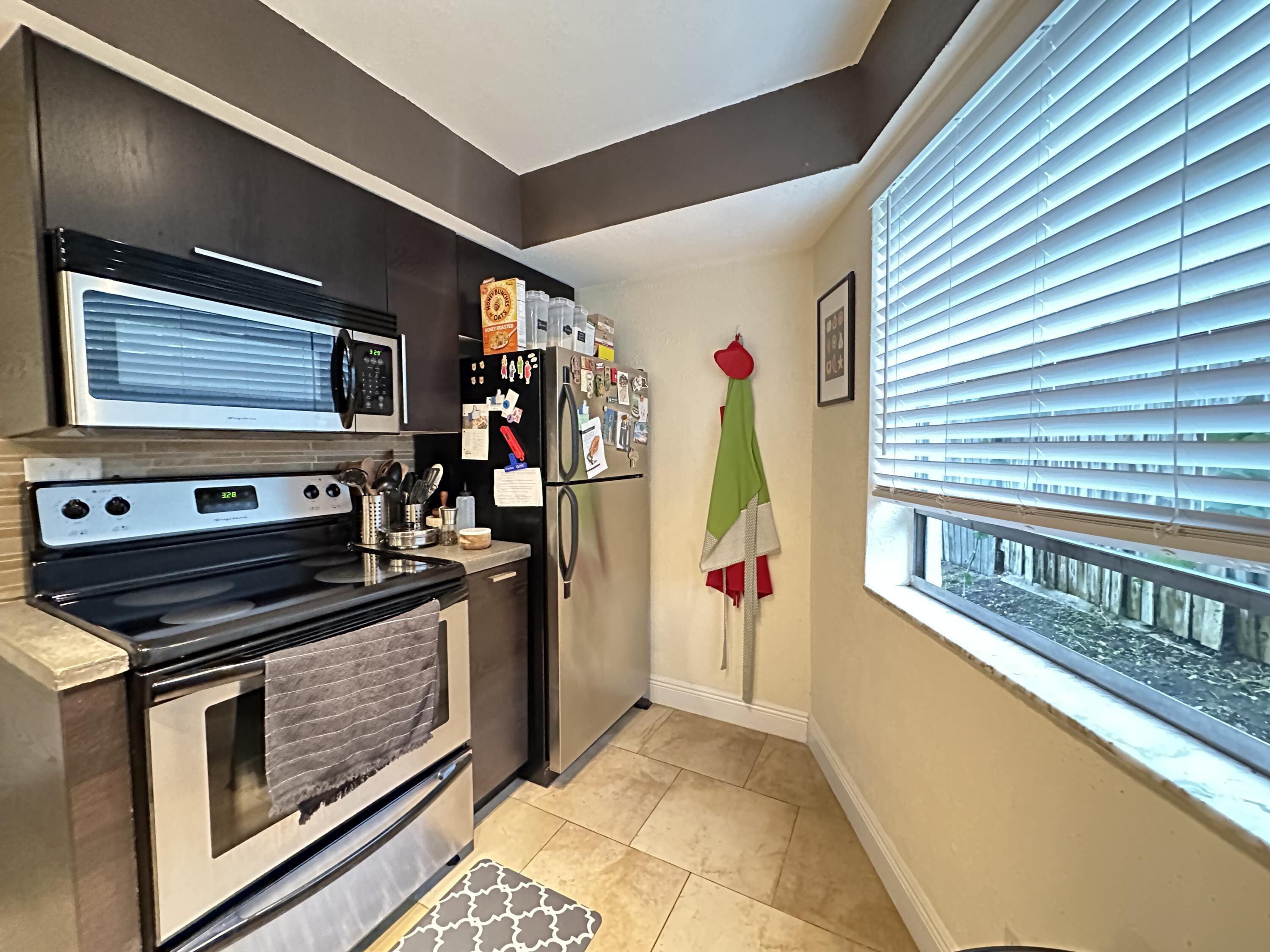 5811 Northeast 14th Road, Unit 1 Fort Lauderdale, FL 33334 - Photo 3 of 16 a view of a kitchen with stainless steel appliances granite countertop a stove and a refrigerator