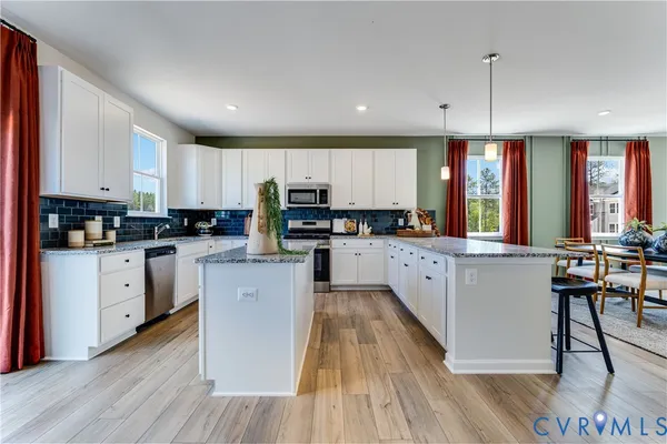 a kitchen with counter top space a sink wooden floor and stainless steel appliances