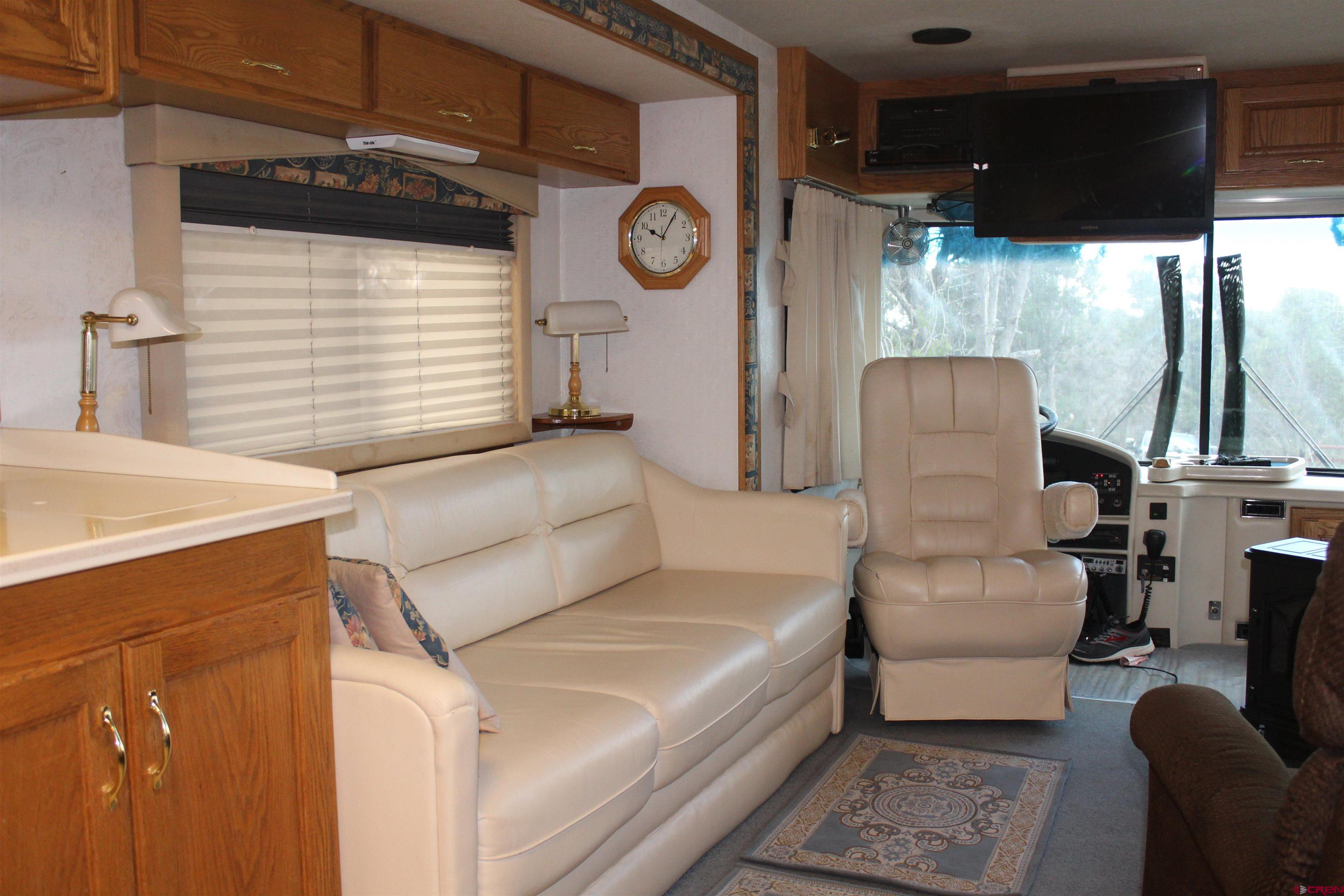 21051 Brimstone Road Cedaredge, CO 81413 - Photo 9 of 25 a living room with furniture a fireplace and a large window