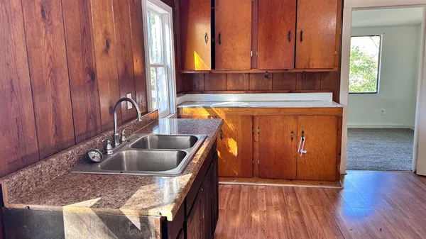 a kitchen with stainless steel appliances granite countertop a sink window and cabinets