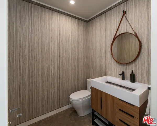 a bathroom with a toilet a sink and a mirror