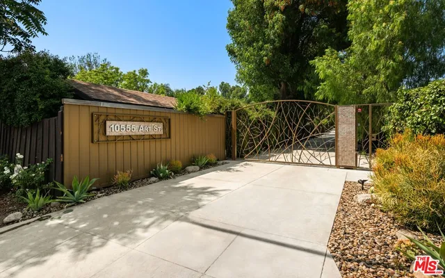 a front view of a house with a yard and potted plants