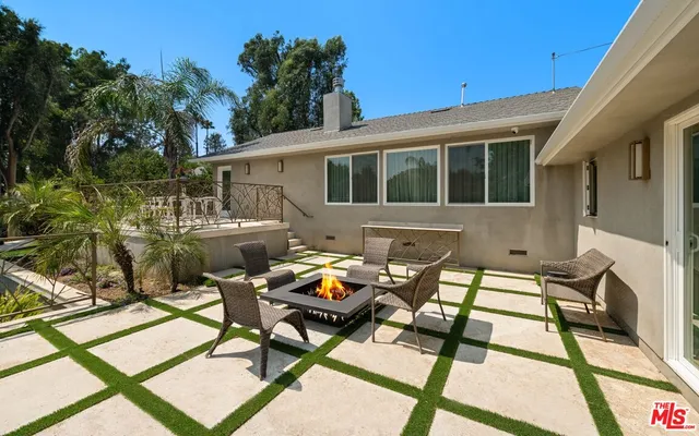 a view of backyard of a house with outdoor seating