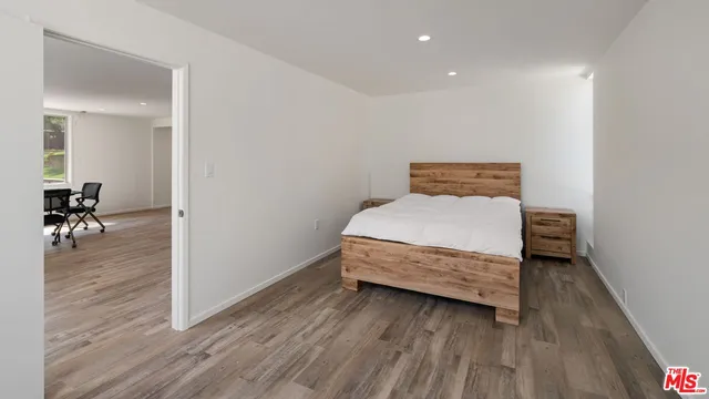 a bedroom with a bed and wooden floor