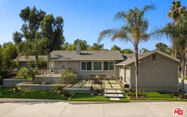 a front view of a house with a garden and plants