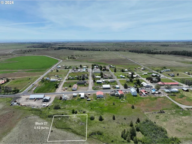 an aerial view of a city with lots of residential buildings ocean and mountain view in back